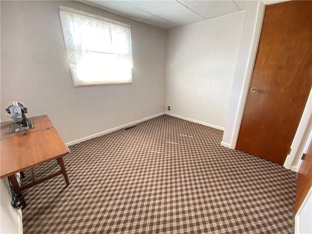 interior space featuring a textured wall, baseboards, and carpet floors