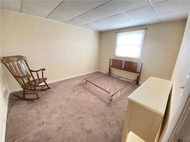 unfurnished room with carpet flooring, a paneled ceiling, and baseboards