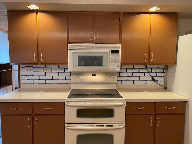 kitchen with white appliances, recessed lighting, light countertops, and backsplash