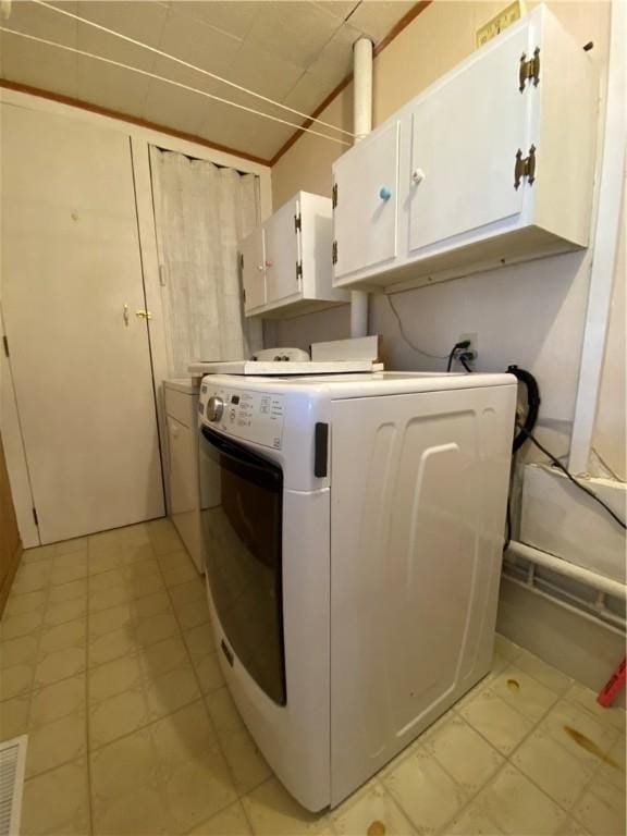 clothes washing area with washer / dryer, visible vents, and cabinet space