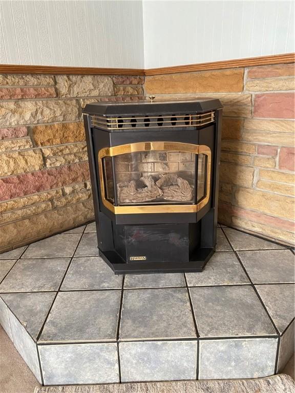 details featuring wainscoting and a wood stove