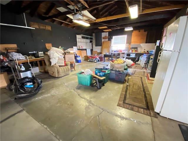 garage with a garage door opener and freestanding refrigerator