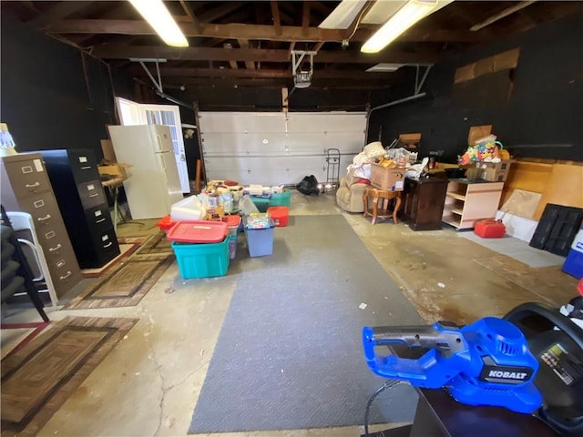 garage with freestanding refrigerator and a garage door opener