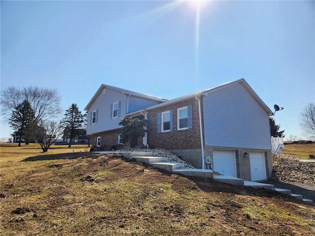 view of side of home with an attached garage and brick siding