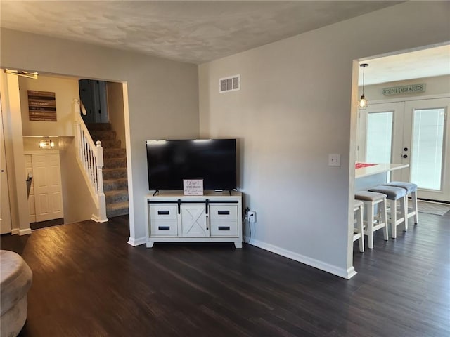 living room featuring dark wood finished floors, visible vents, stairway, and baseboards