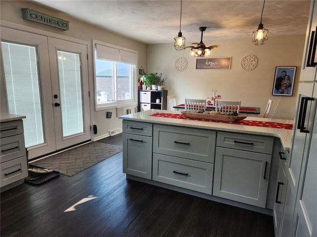 kitchen featuring pendant lighting, french doors, a peninsula, and dark wood-style flooring