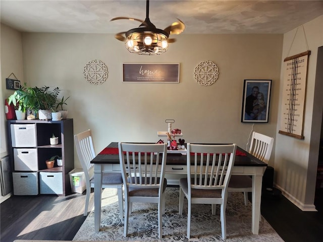 dining space featuring baseboards and wood finished floors