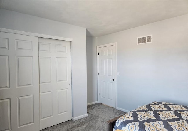 carpeted bedroom with a closet, visible vents, and baseboards