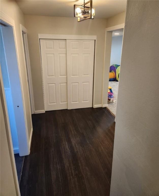 corridor with dark wood-style floors and baseboards