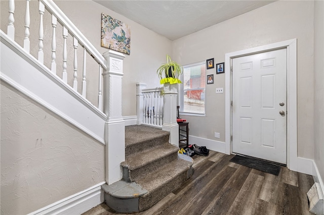 foyer entrance featuring stairway, baseboards, and wood finished floors