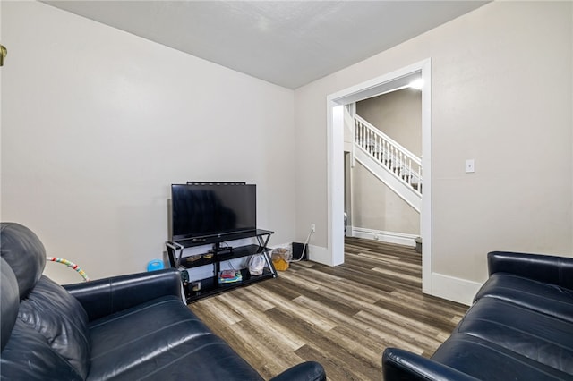 living room with stairway, baseboards, and wood finished floors