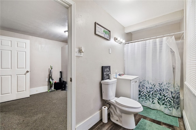 bathroom featuring a sink, a shower with curtain, baseboards, and toilet