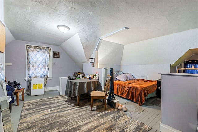 bedroom featuring hardwood / wood-style floors, vaulted ceiling, baseboards, and a textured ceiling