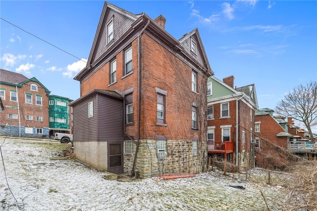 view of side of home featuring brick siding and a chimney