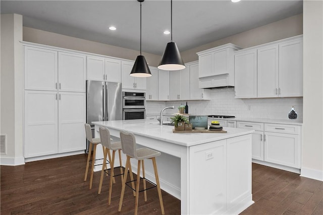 kitchen with visible vents, light countertops, stainless steel appliances, dark wood-style floors, and white cabinetry