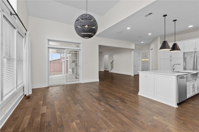 kitchen with visible vents, stainless steel dishwasher, open floor plan, light countertops, and dark wood-style flooring