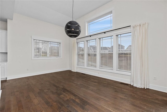 unfurnished dining area with visible vents, baseboards, and dark wood finished floors