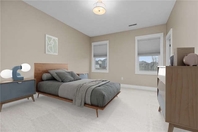 bedroom with light carpet, visible vents, and baseboards