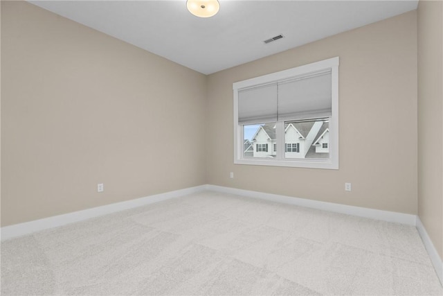 unfurnished room with light carpet, visible vents, and baseboards