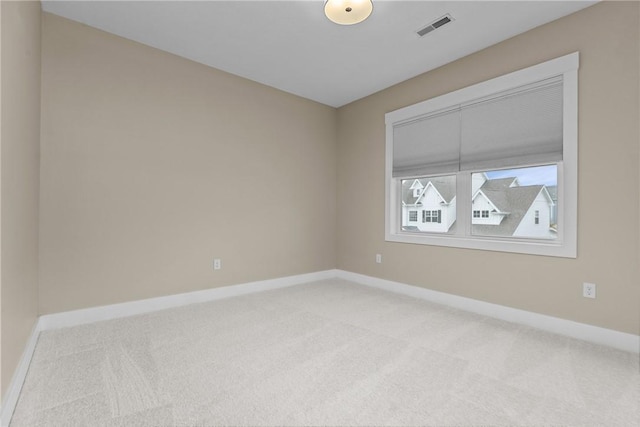 unfurnished room featuring baseboards, visible vents, and light carpet