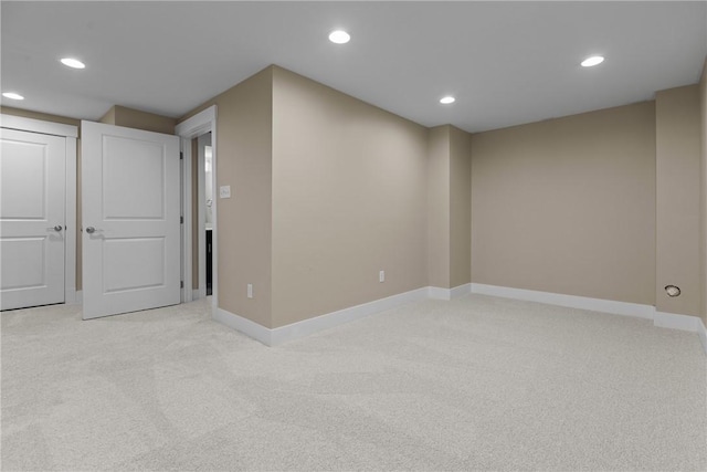 basement with recessed lighting, light colored carpet, and baseboards