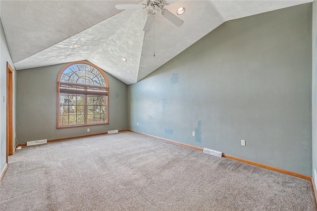 empty room featuring baseboards, visible vents, lofted ceiling, and carpet floors