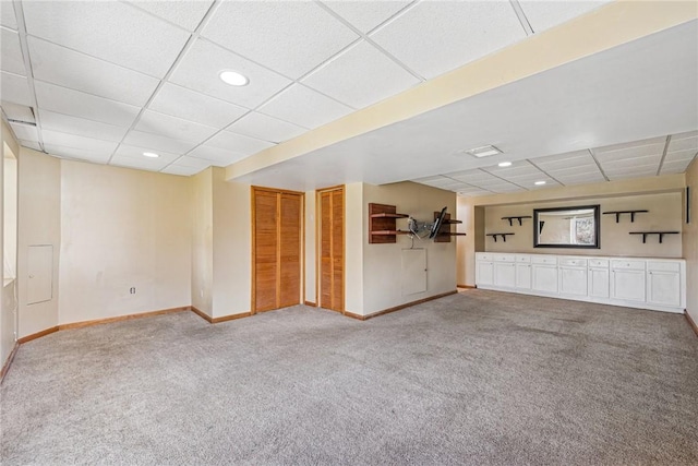 carpeted spare room featuring a drop ceiling, recessed lighting, visible vents, and baseboards