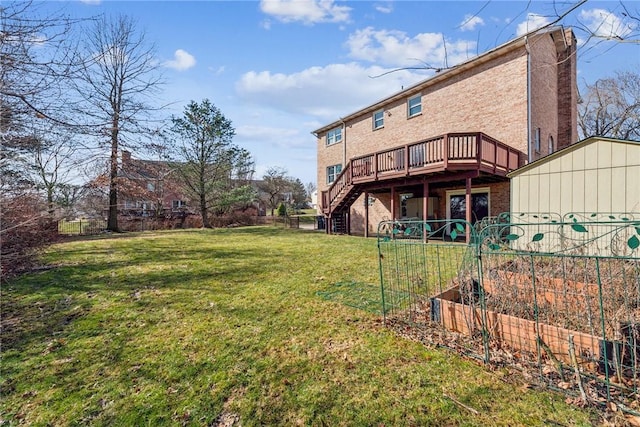 back of house featuring a lawn, a vegetable garden, a wooden deck, brick siding, and stairs