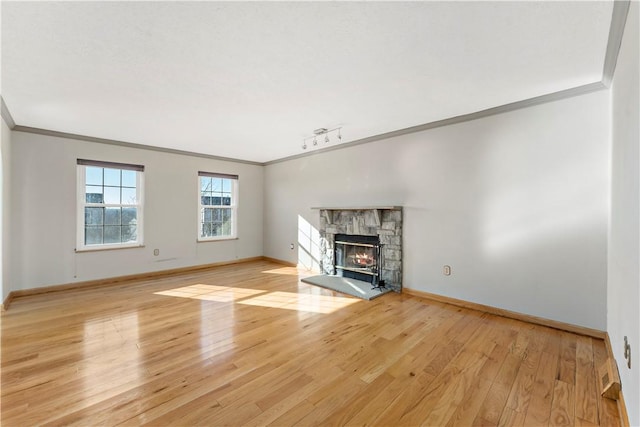 unfurnished living room with baseboards, light wood-style floors, and a fireplace