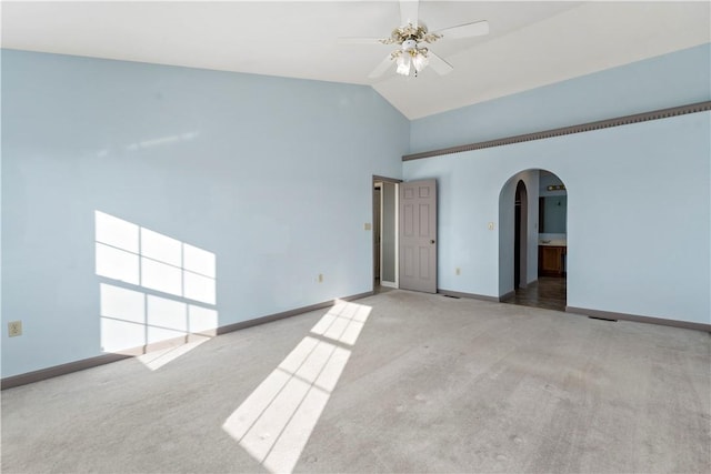 spare room with arched walkways, carpet flooring, high vaulted ceiling, and baseboards