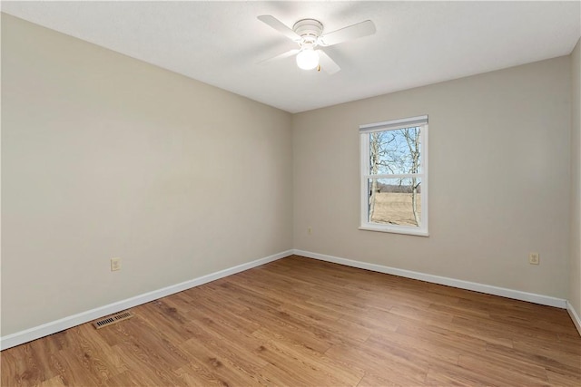 empty room with visible vents, baseboards, light wood-style flooring, and a ceiling fan