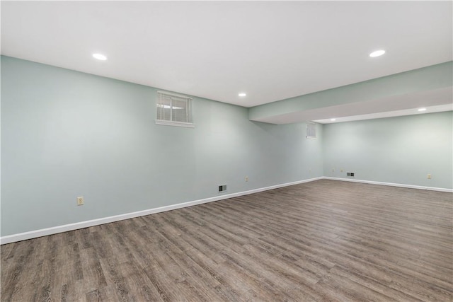 finished below grade area featuring recessed lighting, visible vents, baseboards, and wood finished floors