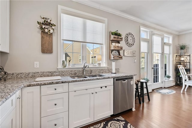 kitchen with white cabinetry, ornamental molding, a sink, dark wood-type flooring, and stainless steel dishwasher