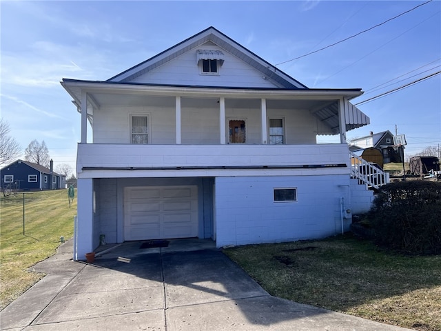 view of front of house featuring a garage, concrete block siding, concrete driveway, and a front lawn