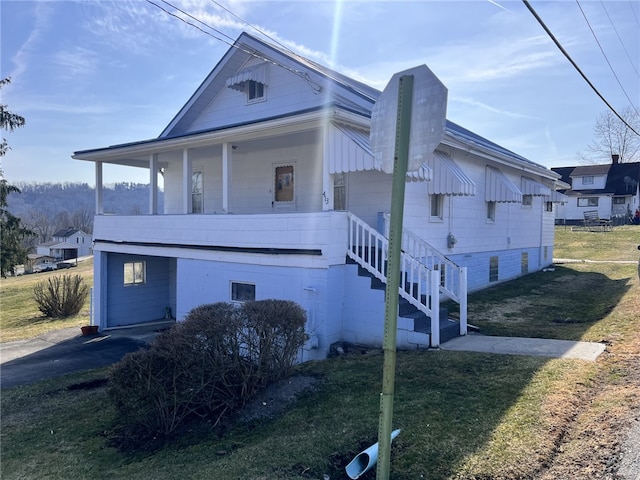 view of side of property featuring stairway and a yard