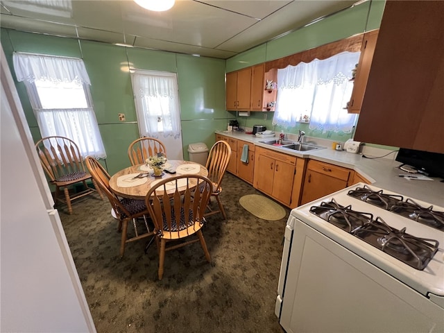 kitchen with a sink, white gas range, and light countertops