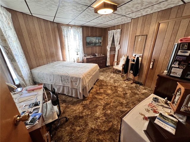 bedroom with carpet floors and wood walls