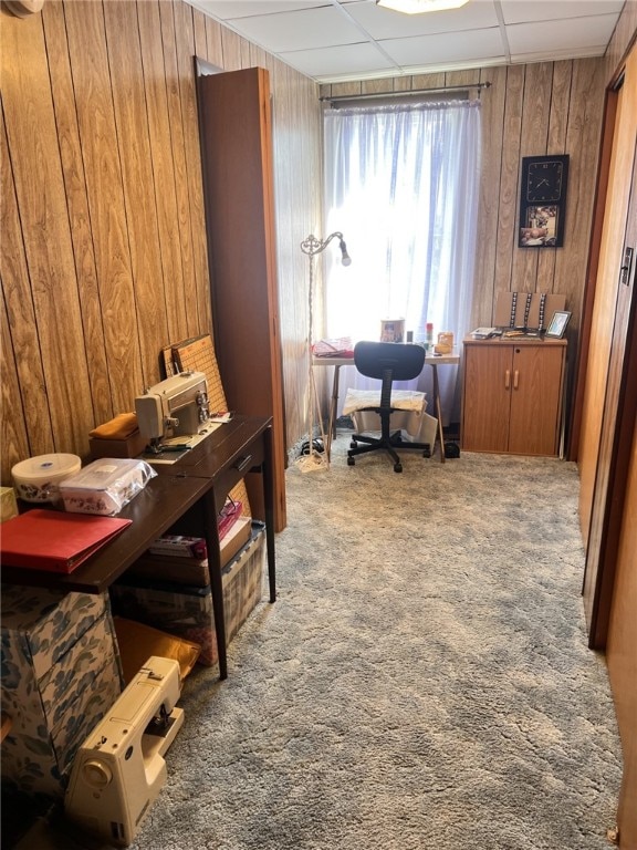 carpeted office with wooden walls and a paneled ceiling