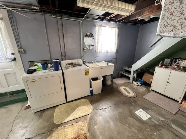 clothes washing area with a sink, laundry area, and washer and clothes dryer