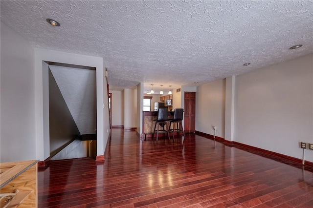 interior space featuring wood finished floors, baseboards, and a textured ceiling