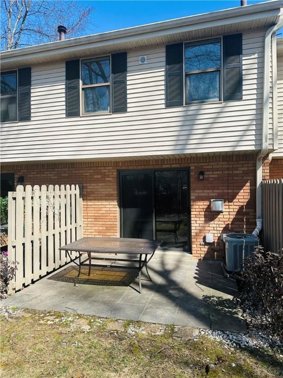 back of house with a patio, central air condition unit, fence, and brick siding