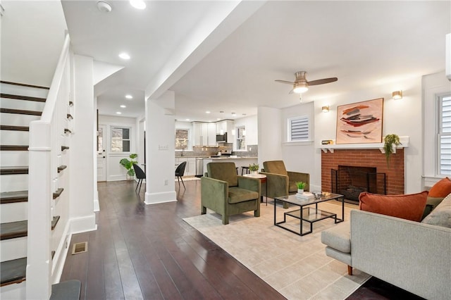 living room with visible vents, stairway, recessed lighting, a fireplace, and dark wood-style floors