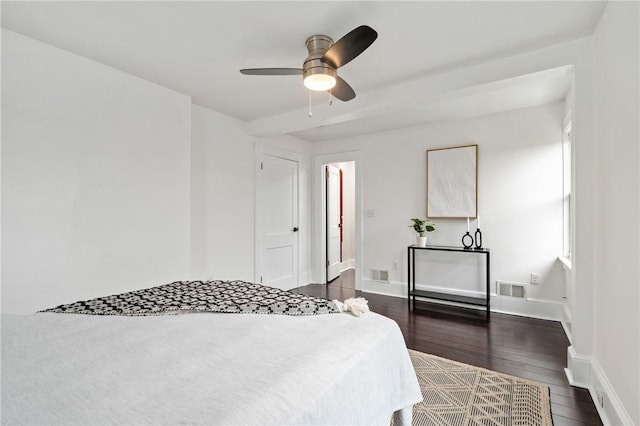 bedroom with dark wood-type flooring, baseboards, visible vents, and ceiling fan