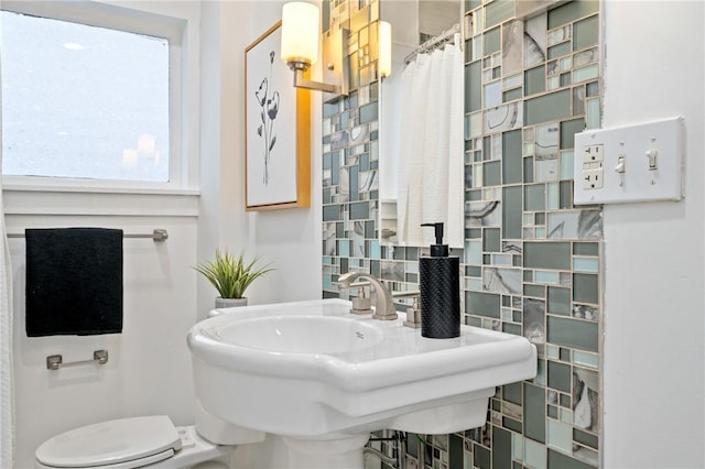 full bath featuring a sink, toilet, and a shower with shower curtain