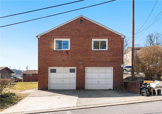 view of side of property with brick siding, driveway, and a garage