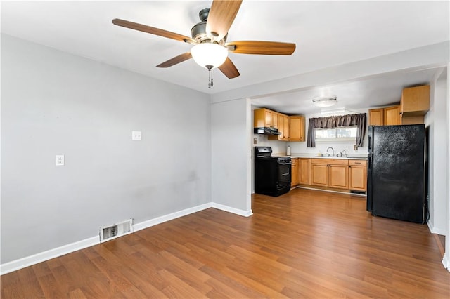 kitchen with visible vents, black appliances, under cabinet range hood, dark wood finished floors, and baseboards