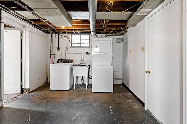 below grade area featuring stacked washer / drying machine and a sink