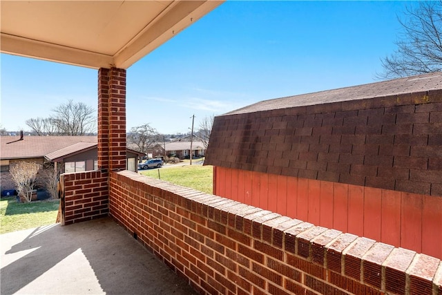 exterior space featuring a balcony and a shingled roof