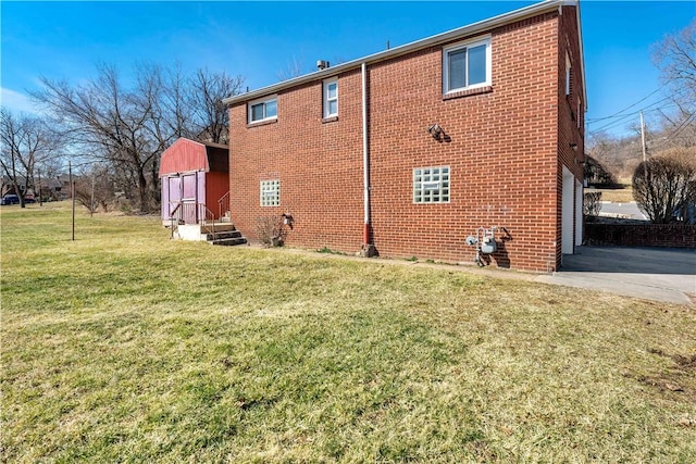 back of property with driveway, a lawn, and brick siding