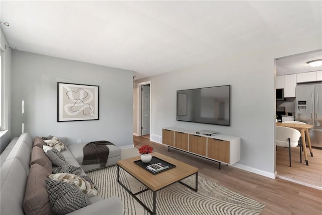 living room featuring light wood-style flooring and baseboards